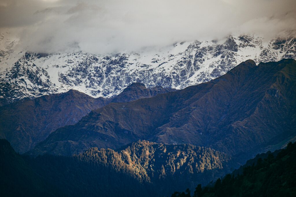 Breathtaking view of snow-capped peaks and rugged terrains in Chopta, India.